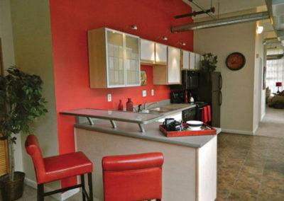 Kitchen with red walls and 椅子 at 圣克莱尔阁楼 apartments for rent in Dayton, OH
