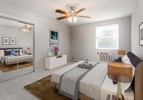 Fully furnished bedroom with a ceiling fan at Eola Park apartments for rent in Philadelphia, PA